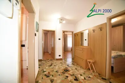 a corridor of a room with a bedroom and a bed at Casa Dolomiti - BERTA in Campitello di Fassa
