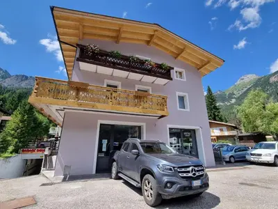a truck parked in front of a building with a balcony at Casa Dolomiti - BERTA in Campitello di Fassa