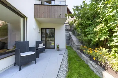 an outdoor patio with chairs and a garden at Apartment Dauru in Ortisei