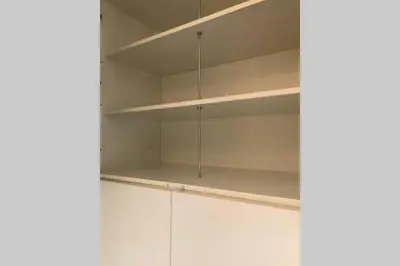 a white cupboard with shelves in a room at Brunico 19 in Brunico