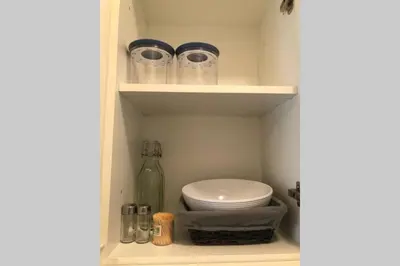 a cupboard with a toilet and a glass bottle at Brunico 19 in Brunico
