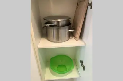 a bathroom with a green bowl and a pot on a shelf at Brunico 19 in Brunico