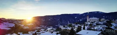 a view of a town with snow covered mountains at Alpine Chalet Aurora Dolomites in Laion