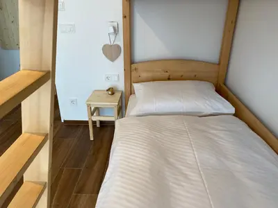 a small bedroom with a bed and a side table at Alpine Chalet Aurora Dolomites in Laion