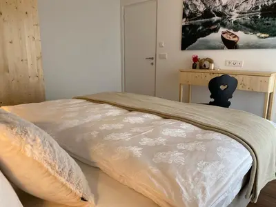 a bed with a blanket on it in a bedroom at Alpine Chalet Aurora Dolomites in Laion