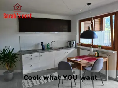 a kitchen with a table and a tv on the wall at Sarah's nest - your mountain resort in Villa Ottone