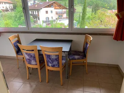 a table and chairs in a room with a window at Santlhof - Sauvignon in Cortaccia