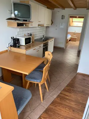 a kitchen with a wooden table and a microwave at Santlhof - Sauvignon in Cortaccia