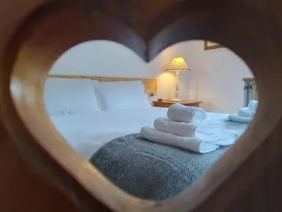 a room with a bed with towels in the shape of a heart at Relax al lago di Braies in Braies