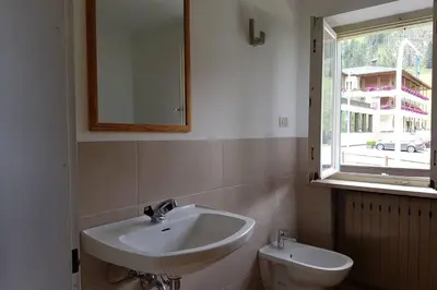 a bathroom with a sink and a toilet and a window at Relax al lago di Braies in Braies