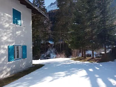 a snow covered yard next to a house with trees at Relax al lago di Braies in Braies