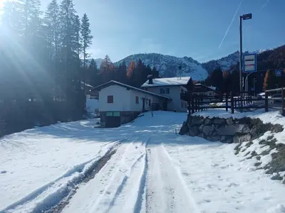 a snow covered road with a building in the distance at Relax al lago di Braies in Braies