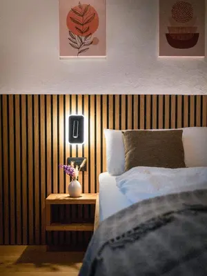 a bedroom with a bed and a table with a lamp at Bergblick Apartment in Zentrumsnähe mit Garage in Merano