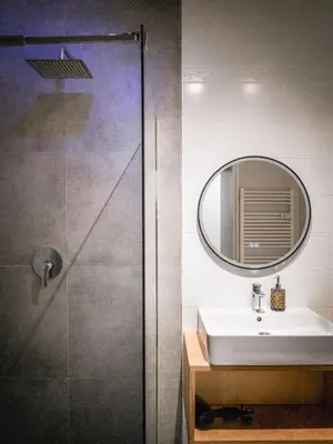 a bathroom with a shower and a sink and a mirror at Bergblick Apartment in Zentrumsnähe mit Garage in Merano