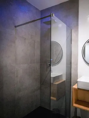a glass shower in a bathroom with a sink at Bergblick Apartment in Zentrumsnähe mit Garage in Merano