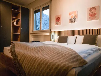 a bedroom with a large bed and a window at Bergblick Apartment in Zentrumsnähe mit Garage in Merano
