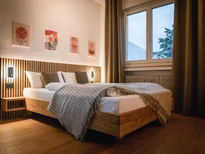 a woman laying on a bed in a bedroom at Bergblick Apartment in Zentrumsnähe mit Garage in Merano