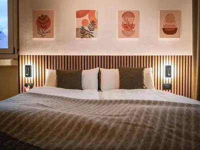 a bedroom with a bed and some pictures on the wall at Bergblick Apartment in Zentrumsnähe mit Garage in Merano