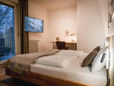 a bedroom with a bed and a desk and a window at Bergblick Apartment in Zentrumsnähe mit Garage in Merano