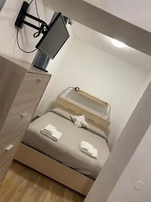 a room with a bed with a desk and a lamp at Appartamento Edelweiss in Fiera di Primiero