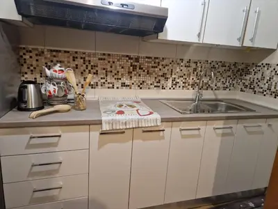 a kitchen with white cabinets and a sink at Appartamento Edelweiss in Fiera di Primiero