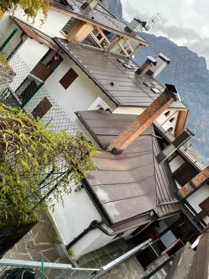 a house with a wooden ramp on the side of it at Appartamento Edelweiss in Fiera di Primiero