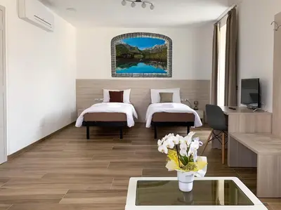 a hotel room with two beds and a tv at B&B ANGELA Valdinon in Predaia
