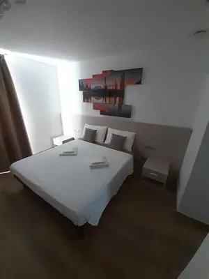 a bedroom with a white bed and a painting on the wall at B&B ANGELA Valdinon in Predaia