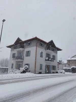 a large white building on the side of a road in the snow at B&B ANGELA Valdinon in Predaia