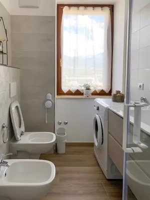 a white bathroom with a sink and a toilet at B&B ANGELA Valdinon in Predaia