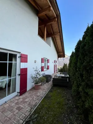 a house with a red door and a patio at Für 4-6 Wohnhaus im Weinberg - Voldersberghof in Penone