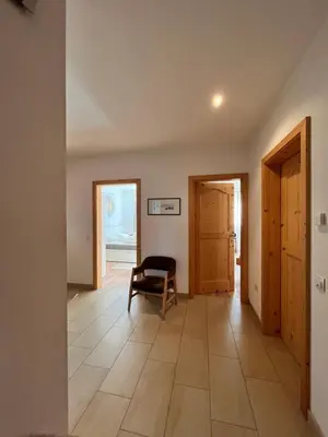 a hallway with a chair and two doors at Für 4-6 Wohnhaus im Weinberg - Voldersberghof in Penone