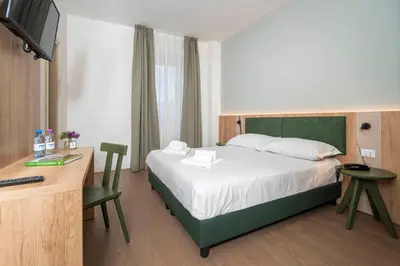 a bedroom with a bed and a desk with a television at Hotel Al Sasso di Stria in Andraz