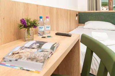 a desk with a laptop and two bottles of water at Hotel Al Sasso di Stria in Andraz