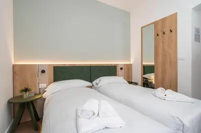 two beds in a room with white sheets and towels at Hotel Al Sasso di Stria in Andraz
