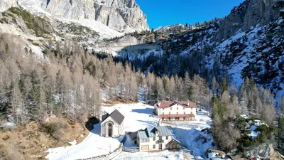 a house in the middle of a snowy mountain at Hotel Al Sasso di Stria in Andraz