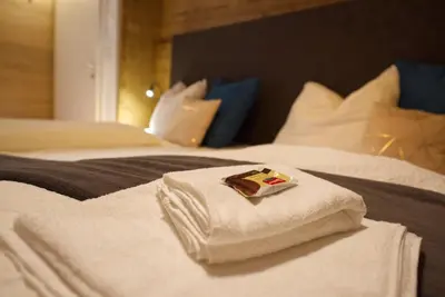 a hotel room with two beds with towels on them at CityChalet family Bozen in Bolzano