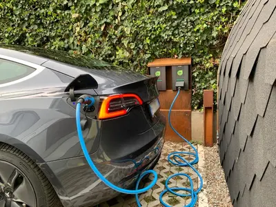 a car is being charged by a blue hose at CityChalet family Bozen in Bolzano