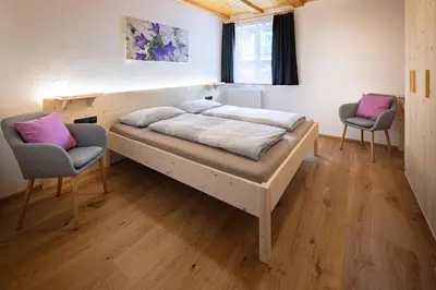a bedroom with a large bed and two chairs at Veraltenhof Agriturismo B&B in Tires