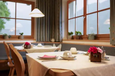 a dining room with tables and chairs with flowers on them at Veraltenhof Agriturismo B&B in Tires