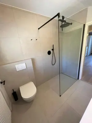 a bathroom with a toilet and a glass shower at Villa Corazza-Bezauberndes Appartment+ Schwimmbad in Tirolo