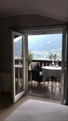 a room with a sliding glass door with a table at Villa Corazza-Bezauberndes Appartment+ Schwimmbad in Tirolo
