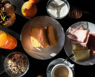 a table with plates of bread and cups of coffee at Hotel Leonhard in Nova Ponente