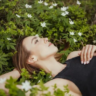 a woman laying in a field of white flowers at Hotel Leonhard in Nova Ponente