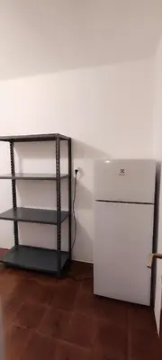 a room with a white refrigerator and a shelf at Große Wohnung mit Garagenparkplatz in Vols am Schlern
