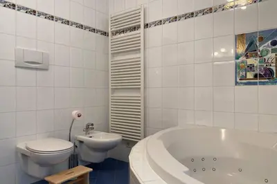 a bathroom with a toilet and a tub and a sink at Große Wohnung mit Garagenparkplatz in Vols am Schlern