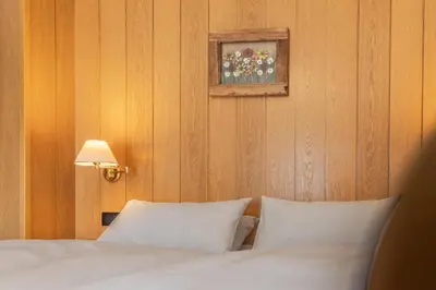 a bedroom with a bed with white pillows and a picture at Villa Resi B&B in Corvara in Badia