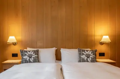 a bedroom with two beds with pillows and two lamps at Villa Resi B&B in Corvara in Badia