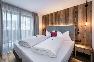 a bedroom with a large white bed with white pillows at Guesthouse Plose in Bressanone