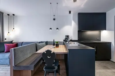 a kitchen and living room with a table and a couch at Guesthouse Plose in Bressanone